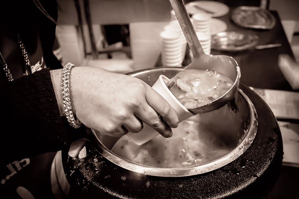 Soup being poured into a cup (monochrome)